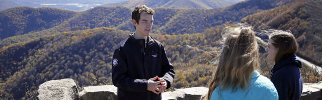 Crew members standing in front of fall mountains