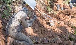 Crew member works on trail on the ground