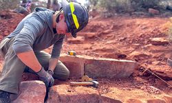 Crew member sits and does rockwork on some steps