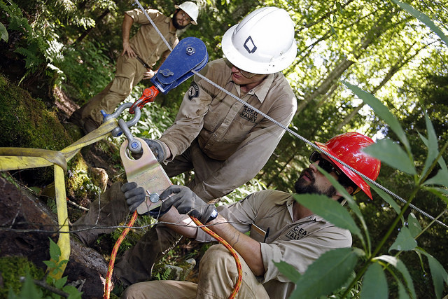 Crew members working with the griphoist to lift a rock