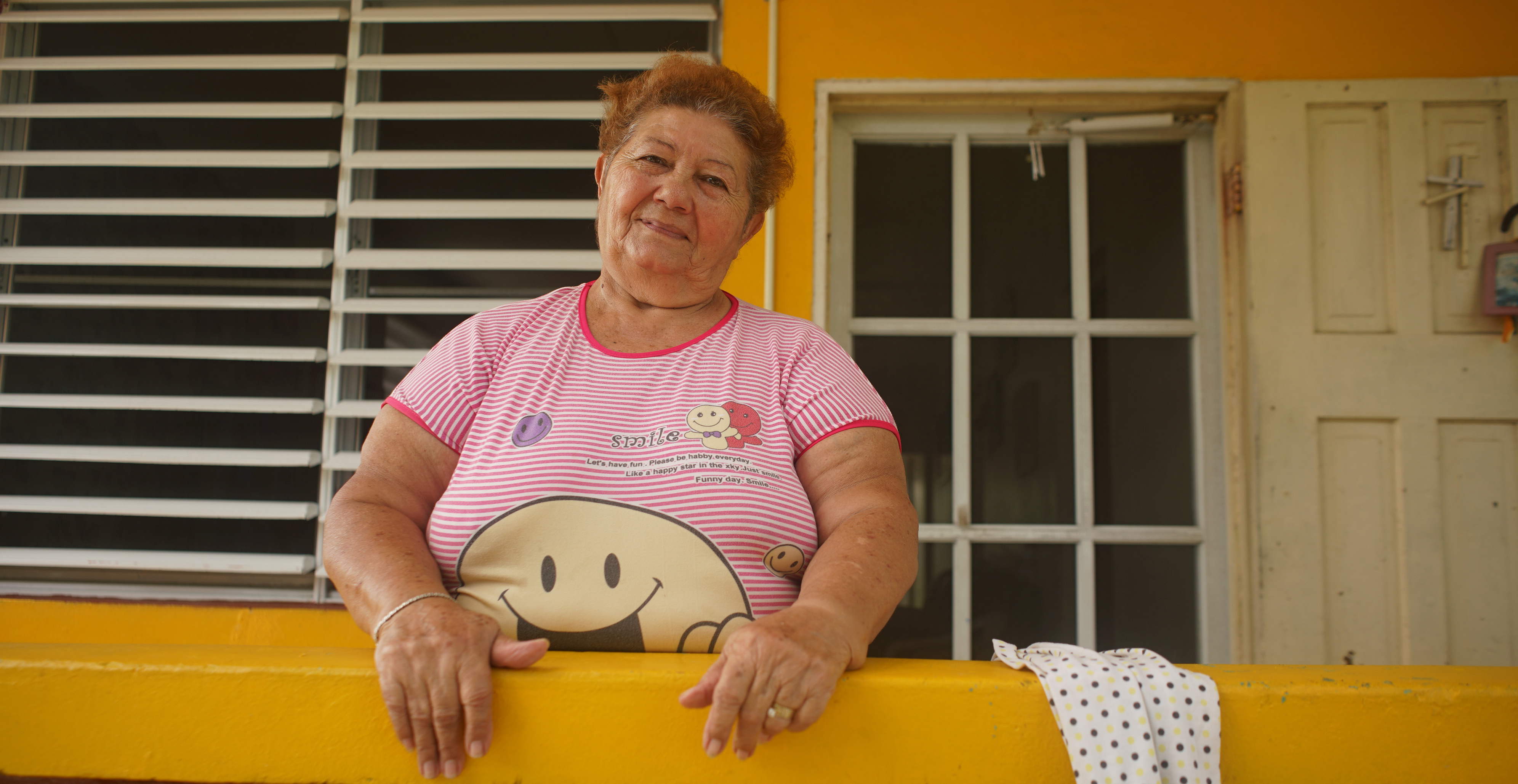 Smiling community member on her porch